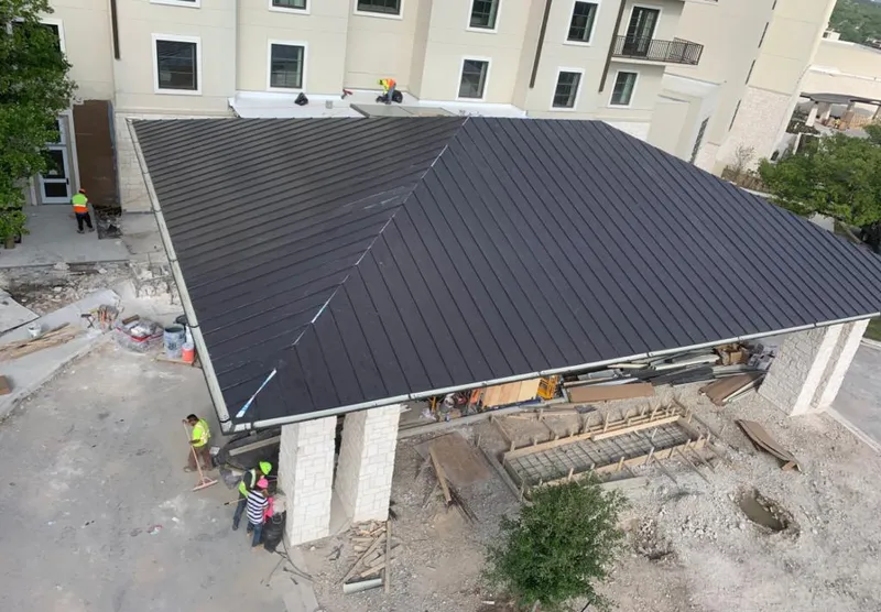 Metal roofing installation team working on a commercial building in Rye